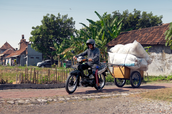 Indonesian man on bike with collection of Ocean-Bound Plastic pollution soon to turn into POLLAST!C